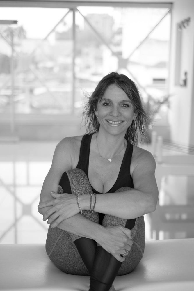 Instructora de Flow Pilates sentada en el estudio, sonriendo